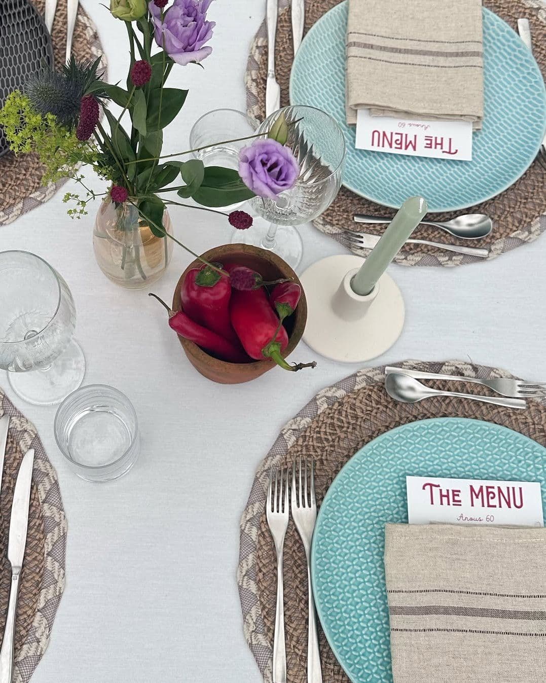 Detail van een gedekte tafel met menukaart en bloemen