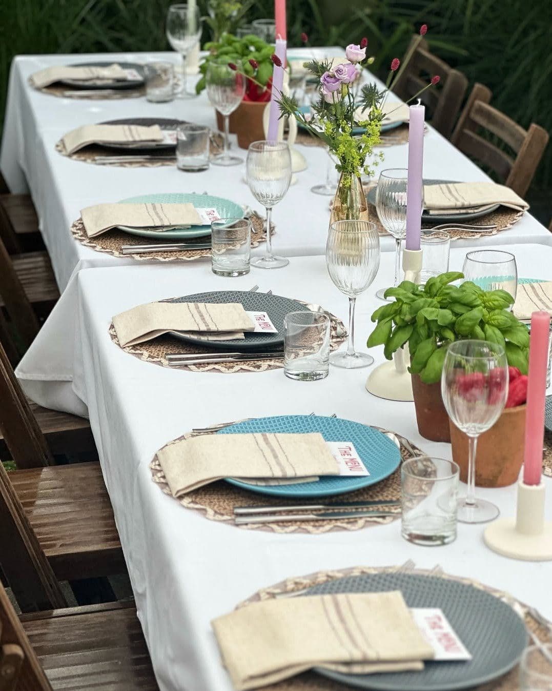 Feestelijk gedekte lange tafel met kaarsen en bloemen